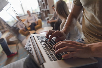 Image showing close up of male hands while working on laptop