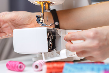 Image showing Seamstress starts tailoring on sewing-machine