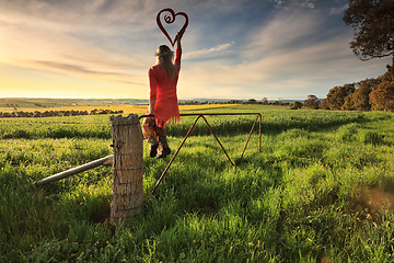 Image showing Escape to the Country - female on fence with love heart in morni