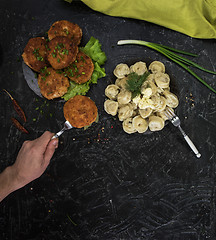 Image showing Fried cutlets and russian pelmeni on black background