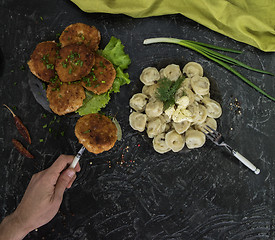 Image showing Fried cutlets and russian pelmeni on black background