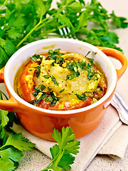 Image showing Fish baked with tomato in red pot on stone table