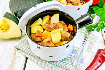 Image showing Roast meat and vegetables in white pots on towel