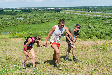 Image showing Man helps the girl to rise on hill. Tyumen