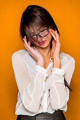 Image showing The serious frustrated young beautiful business woman on orange background