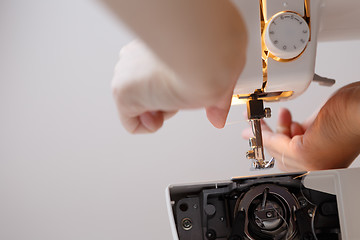 Image showing Woman inserts thread in sewing-machine