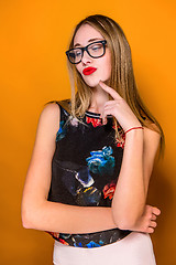 Image showing The serious frustrated young beautiful business woman on orange background