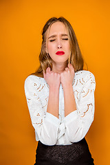 Image showing The serious frustrated young beautiful business woman on orange background