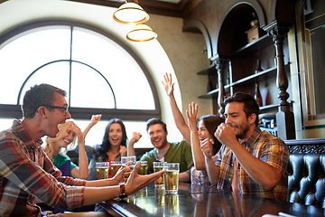 Image showing friends with beer watching football at bar or pub