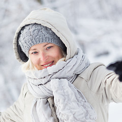 Image showing Girl  playing with snow in winter.