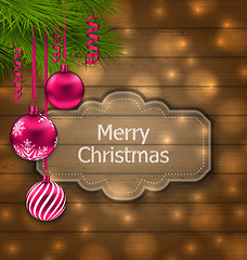 Image showing Christmas label with balls and fir twigs on wooden texture with 