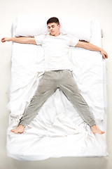 Image showing The young man lying in a bed