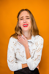 Image showing The serious frustrated young beautiful business woman on orange background