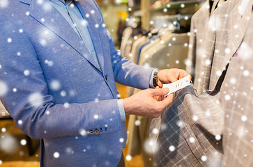 Image showing close up of man choosing clothes in clothing store