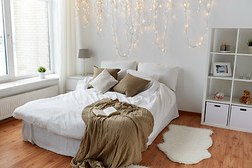 Image showing bedroom with bed and christmas garland at home