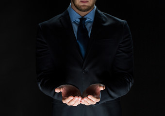 Image showing close up of businessman holding something in hands