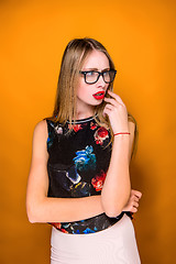 Image showing The serious frustrated young beautiful business woman on orange background