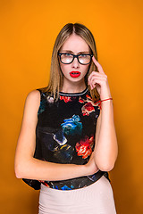 Image showing The serious frustrated young beautiful business woman on orange background