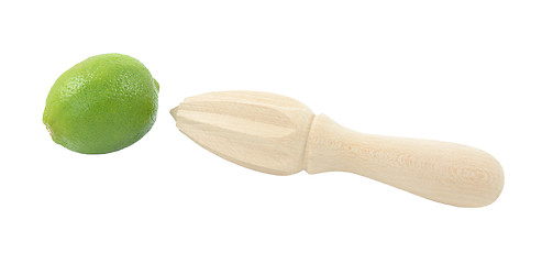 Image showing Whole lime and wooden citrus reamer