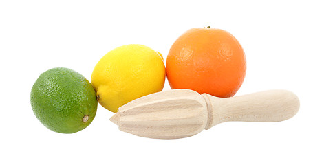 Image showing Lime, lemon and orange fruit with wooden citrus reamer