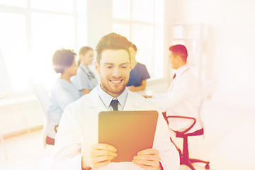 Image showing happy doctor with tablet pc over team at clinic