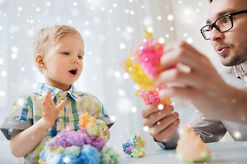 Image showing father and son playing with ball clay at home