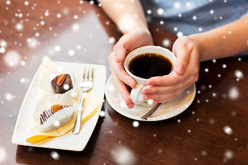 Image showing close up of woman holding coffee cup and dessert