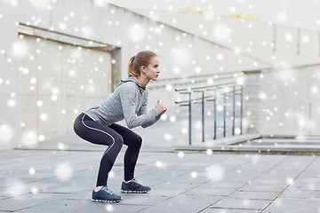 Image showing woman doing squats and exercising outdoors