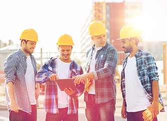 Image showing group of smiling builders with tablet pc outdoors