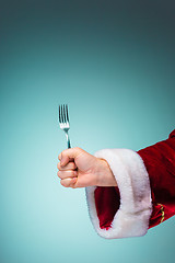 Image showing The Santa hand holding a fork