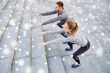 Image showing couple of sportsmen doing squats and exercising