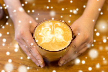 Image showing close up of hands with latte art in coffee cup