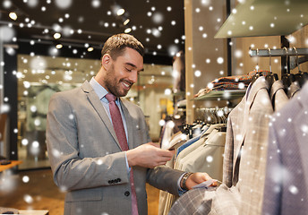 Image showing man in suit with smartphone at clothing store