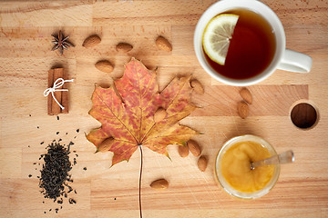 Image showing cup of lemon tea and honey on wooden board