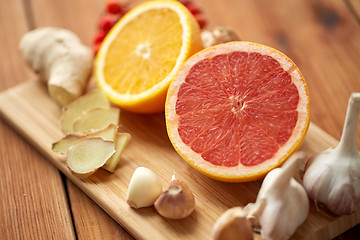 Image showing grapefruit, ginger, garlic and orange on board