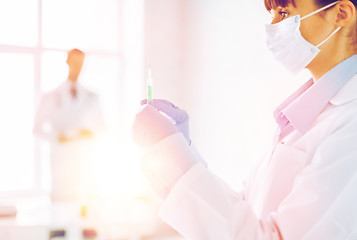 Image showing female doctor holding syringe with injection