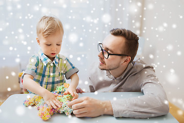 Image showing father and son playing with ball clay at home