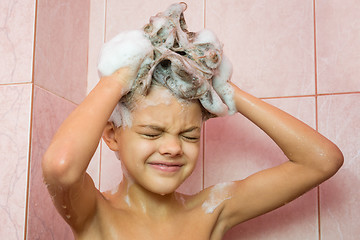 Image showing Seven-year girl washing her hair with shampoo