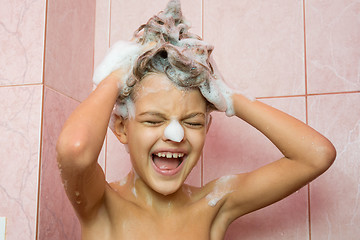 Image showing Funny girl washing her hair with shampoo