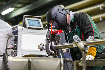 Image showing Industrial worker setting orbital welding machine.