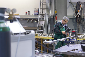 Image showing Industrial worker setting orbital welding machine.