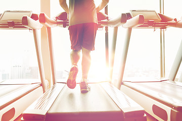 Image showing close up of male legs running on treadmill in gym