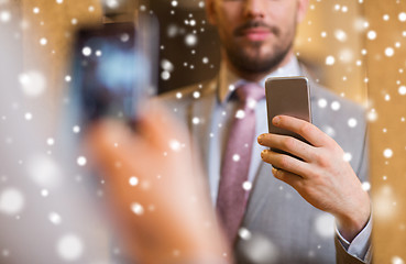 Image showing close up of man in suit taking mirror selfie