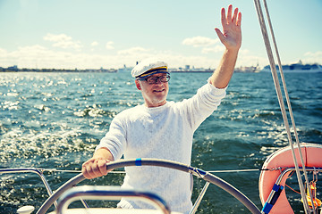 Image showing senior man at helm on boat or yacht sailing in sea