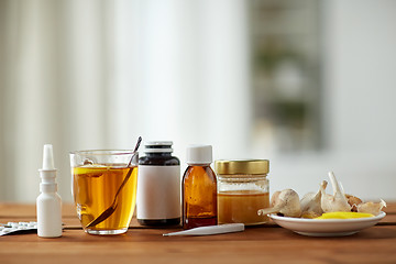 Image showing drugs, thermometer, honey and cup of tea on wood