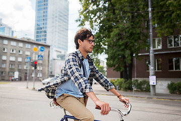 Image showing young hipster man with bag riding fixed gear bike