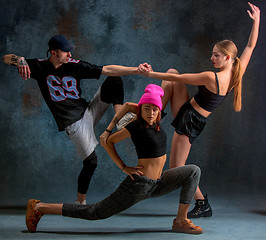 Image showing The two young girsl and boy dancing hip hop in the studio