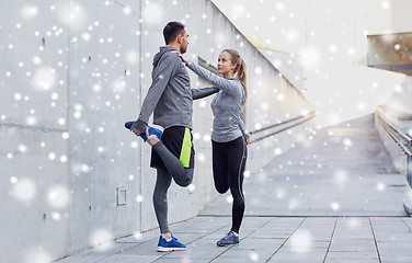 Image showing couple of sportsmen stretching leg outdoors