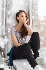 Image showing sad pretty teenage girl looking through window