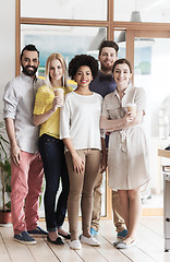 Image showing happy smiling creative team with coffee in office